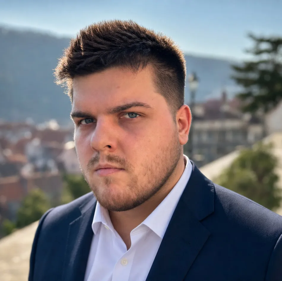 Portrait of Dominik Pałka wearing a navy suit outdoors
